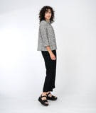model in a black straight leg pant with a white and black striped button down top with elbow length sleeves