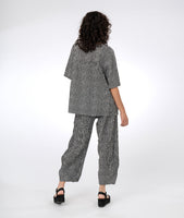 model in a wide leg black and white striped pant, with a matching top in black and white striped color blocking 