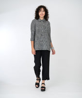 model in a slim black pant with a black and white striped top