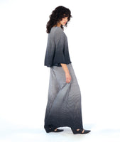 model in a ultra wide leg palazzo pant in a black and white grid ombre print, worn with a matching pullover top with a wide body and wide sleeves, giving a bell shape