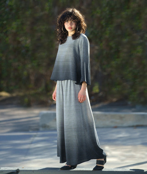 model in a wide leg pant in a white to black grid ombre print, and a matching pullover top with a full bell shaped body and wide sleeves