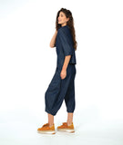 model wearing a dark wash chambray button down blouse with 3/4 sleeves and a twin button detail. worn with a matching barrel leg pant with oversized pockets and a yellow shoe
