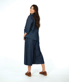 model in a dark wash chambray jacket with a small split at the waist seam. Jack has 3/4 sleeves and sits open. Worn with a matching wide leg pant