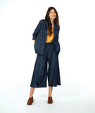 model in a dark wash chambray jacket with a small split at the waist seam. Jack has 3/4 sleeves and sits open. Worn with a matching wide leg pant and yellow top