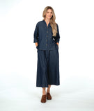 model in a dark wash chambray button down blouse with a princess seam and dolman sleeve. worn with a matching wide leg pant with brown loafers
