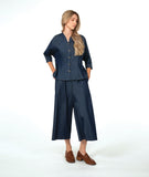 model in a dark wash chambray button down blouse with a princess seam and dolman sleeve. worn with a matching wide leg pant with brown loafers