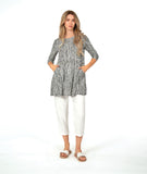 model in a white crop pant with a black and white striped top with contrasting panels and pockets