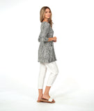 model in a white crop pant with a black and white striped top with contrasting panels and pockets