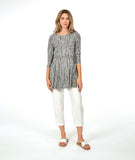 model in a white crop pant with a black and white striped top with contrasting panels and pockets