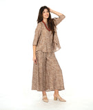 model in a wide leg pant with a pullover top with 3/4 sleeves and a flowy body. Top and pant are both taupe with a white leaf print