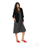 model in a long black tank dress with white polkadots, with a black open jacket