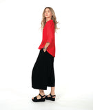 A woman modeling a bright red button-up blouse with three-quarter sleeves and black wide-leg pants,with an overlapping front 