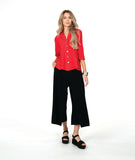 A woman modeling a bright red button-up blouse with three-quarter sleeves and black wide-leg pants,with an overlapping front 
