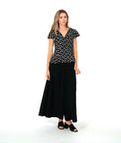 A woman modeling a black short-sleeve top with white polka dots and a long wide leg black pant. top has a v-neck, peplum and fluttery sleeves