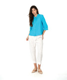 model in a white cropped pant with a bright blue button up blouse