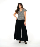 model in a wide leg black pant with and over lapping front panel. worn with a black and white stripe pullover top with a flutter peplum and sleeves, and a v neck with contrasting stripe panels 