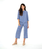 model in a two piece set consisting of a blue and white cargo pant and a button down blouse with 3/4 sleeves and a twin button detail