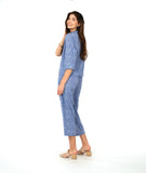 model in a two piece set consisting of a blue and white cargo pant and a button down blouse with 3/4 sleeves and a twin button detail