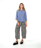 model in a blue and white striped button down with a matching pant in a black and white stripe. pant is barrel leg shaped with oversized pockets