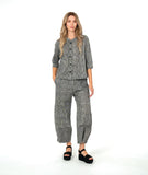model in a black and white striped barrel leg pant with a matching button down blouse with 3/4 sleeves and a double button detail