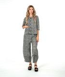 model in a black and white striped barrel leg pant with a matching button down blouse with 3/4 sleeves and a double button detail