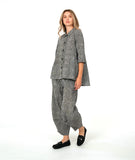 model in a black and white stripe wide leg pant with a mid calf tuck detail. worn with a matching blouse with 3/4 sleeves, a flowy body, and oversized pockets
