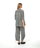 model in a black and white stripe wide leg pant with a mid calf tuck detail. worn with a matching blouse with 3/4 sleeves, a flowy body, and oversized pockets