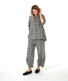 model in a black and white stripe wide leg pant with a mid calf tuck detail. worn with a matching blouse with 3/4 sleeves, a flowy body, and oversized pockets