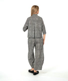 model in a black and white striped barrel leg pant with a mid calf tuck detail. worn with a matching blouse with a contrasting stripe placket and cuff