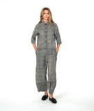 model in a black and white striped barrel leg pant with a mid calf tuck detail. worn with a matching blouse with a contrasting stripe placket and cuff