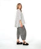 model in a barrel leg stripe pant with a white button down with black dots