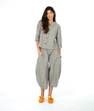 A woman modeling a matching two-piece set consisting of a grey button-up shirt and cropped pants in a with a yellow textured dot pattern. Paired with yellow shoes, on a white studio background.