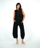 model in a black sleeveless blouse with a textured dot pattern. worn with a barrel leg matching pant