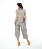 model in a wide barrel leg pant in a soft grey and white stripe with a yellow textured dot print. worn with a matching cap sleeve blouse with yellow buttons
