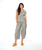 model in a wide barrel leg pant in a soft grey and white stripe with a yellow textured dot print. worn with a matching cap sleeve blouse with yellow buttons