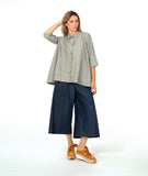 model in a wide leg chambray pant, with a long button down blouse in a grey and white stripe with a yellow  texture dot detail. 