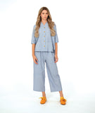 model in a wide leg cargo pant, worn with a matching button down blouse in a blue and white stripe with a yellow texture dot detail.  blouse has external squared pockets and  3/4 sleeve