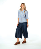 model in a wide leg chambray pant, with a long button down blouse in a blue and white stripe with a yellow texture dot detail.  blouse has external squared pockets and  3/4 sleeve