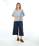model in a wide leg chambray pant, with a long button down blouse in a blue and white stripe with a yellow texture dot detail.  blouse has external squared pockets and  3/4 sleeve