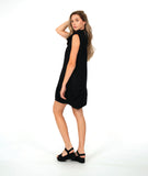 model in a black sleeveless dress with an oversized cowl neck. dress is black with small textured dots, and has side seam pockets, princess seams and shaping tucks at the hips