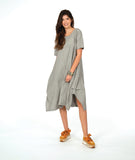 A woman modeling a loose, short-sleeve midi dress with a gray and white vertical stripe pattern with a textured yellow dot. dress has an asymmetrical body, scoop neck and elbow length sleeves