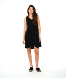 model in a sleeveless, knee length dress with an asymmetrical skirt. dress is black with a small textured dot print