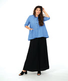model in a blue color button down with a swirl texture. blouse has 3/4 sleeves and oversized rounded pockets at the hip. Worn with a wide leg black pant