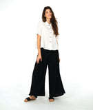 model in a short sleeve white button down with a black wide leg pant