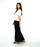model in a short sleeve white button down with a black wide leg pant