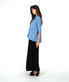 model in a blue color button down with a swirl texture. blouse has 3/4 sleeves and oversized rounded pockets at the hip. Worn with a wide leg black pant