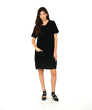 model in a black knee length dress with short sleeves and a round neckline. dress has a swirl texture and a diagonal seam across the body with a hidden seam pocket on the right