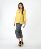 model in a yellow pullover top with 3/4 sleeves, a collar and a deep v. worn with a slim grey crop pant