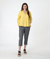 model in a yellow pullover top with 3/4 sleeves, a collar and a deep v. worn with a slim grey crop pant