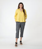 model in a yellow pullover top with 3/4 sleeves, a collar and a deep v. worn with a slim grey crop pant